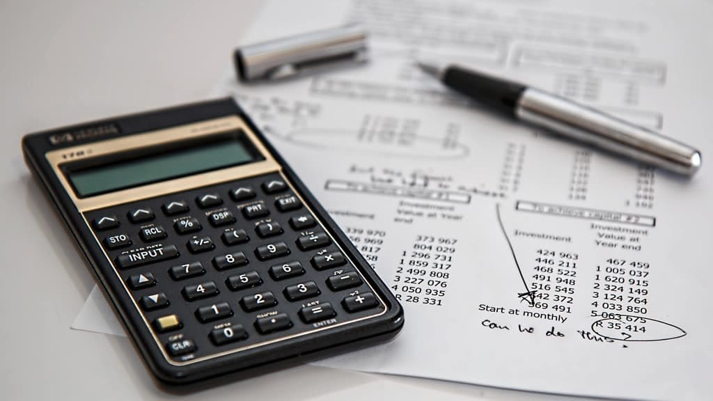 Calculator and pen lying on a printed sheet of figures